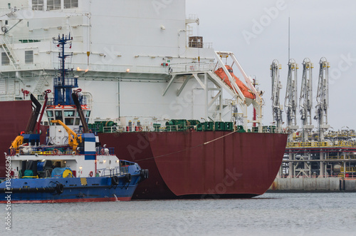LNG TERMINAL IN SWINOUJSCIE - Tanker moored to a gas connection with the help of a tugboat