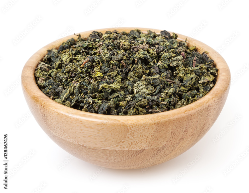 Dry green oolong tea in wooden bowl isolated on white background with clipping path Dry green oolong tea in wooden bowl isolated on white background with clipping path