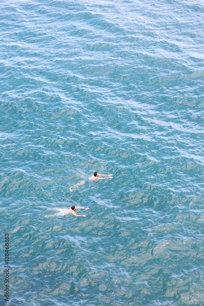 Two people floating in the turquoise sea surface. Amalfi, Italy.