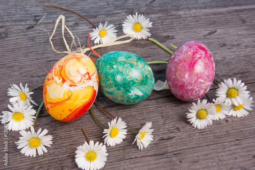 Easter eggs on wooden background, with flowers for card