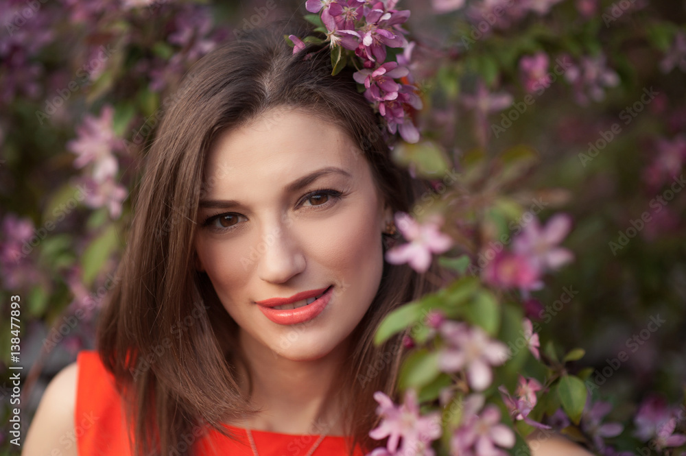 beautiful young woman near the blossoming spring tree