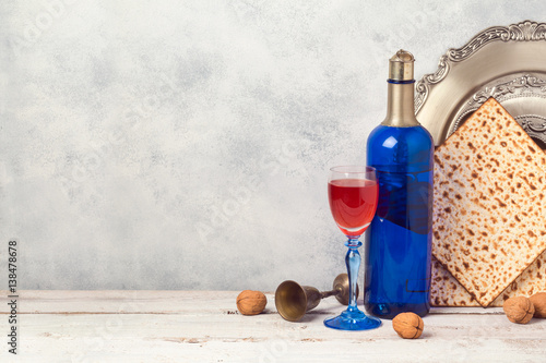 Passover holiday concept with blue wine bottle and matzoh over rustic background with copy space