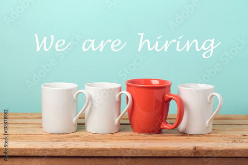 Job recruit concept with coffee cups and text "We are hiring". Business background