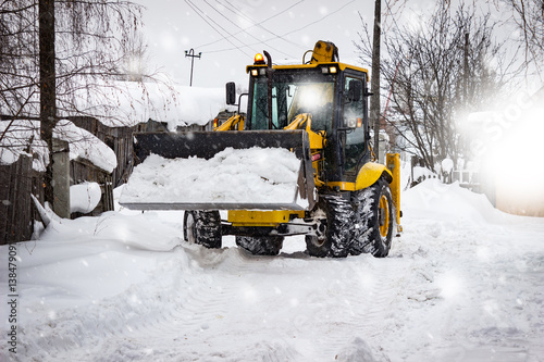 Snow clearing. Tractor clears the road after snowfall