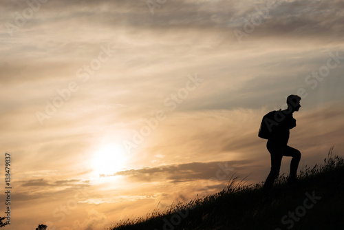 teamwork of two man at the top of mountain. silhouette at sunset