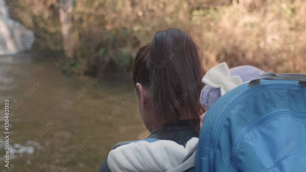 Close-Up Follow Cam of Baby in Hiking Backpack with Mom at Waterfall Close-Up Follow Cam of Baby in Hiking Backpack with Mom at Waterfall
