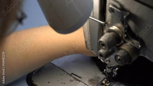 Dressmaker sewing clothes on the sewing machine with two needles