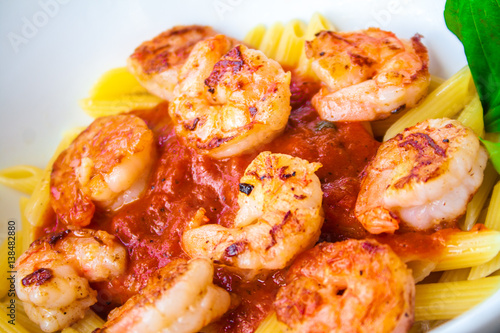 Pasta with fresh sauce and shrimps on a white plate background.