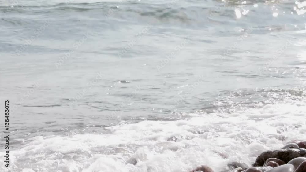 waves crash over a rocky beach closeup waves crash over a rocky beach closeup