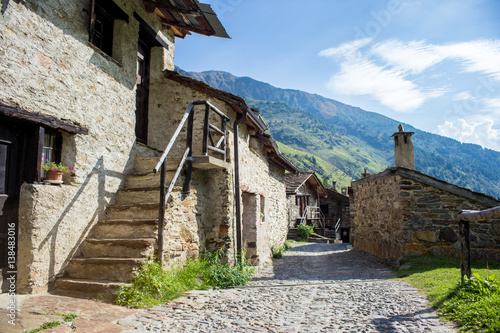 Stone chalets in a tiny mountaing village. Case di Viso - Ponte di Legno, Italy photo