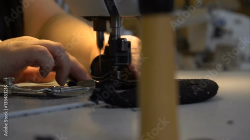 Dressmaker sewing clothes on the sewing machine using a thick needle
