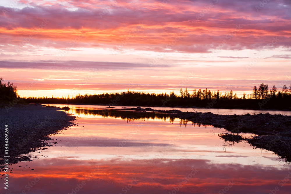 Sunset on the taiga river. River Omulevka. Yakutia. Russia.