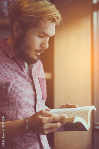 Young man reading a book at the coffee shop
