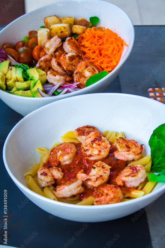 Fresh pasta with shrimp and tomato sauce with basil in a white bowl. Fresh pasta with shrimp and tomato sauce with basil in a white bowl.