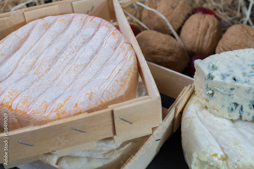 Different french soft cheeses on black stone platter