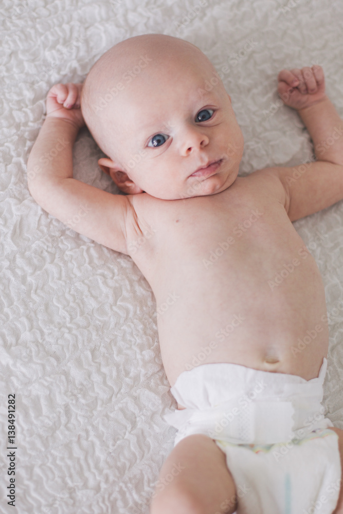 Portrait of newborn baby lying on parents bed. Portrait of newborn baby lying on parents bed.
