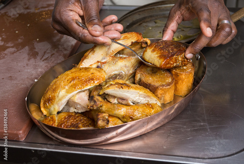 Roasted chicken with foie gras being served in a metal pan.