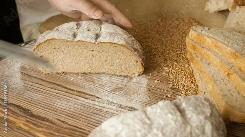 Cut slice of bread on the wooden table, in slow motion, close up