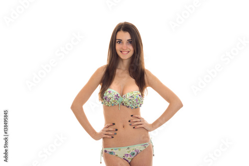 a young attractive girl in bathing suit holding hands on the sides and smiling