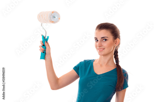 a young girl in a t-shirt holding a roller for painting walls