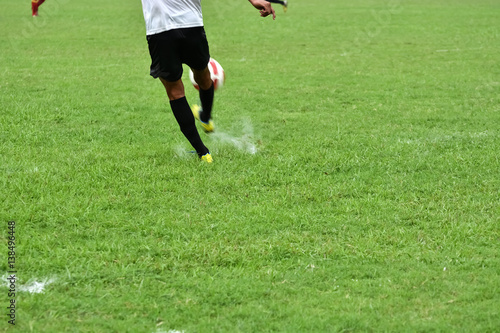 Boy is running to kick soccer ball