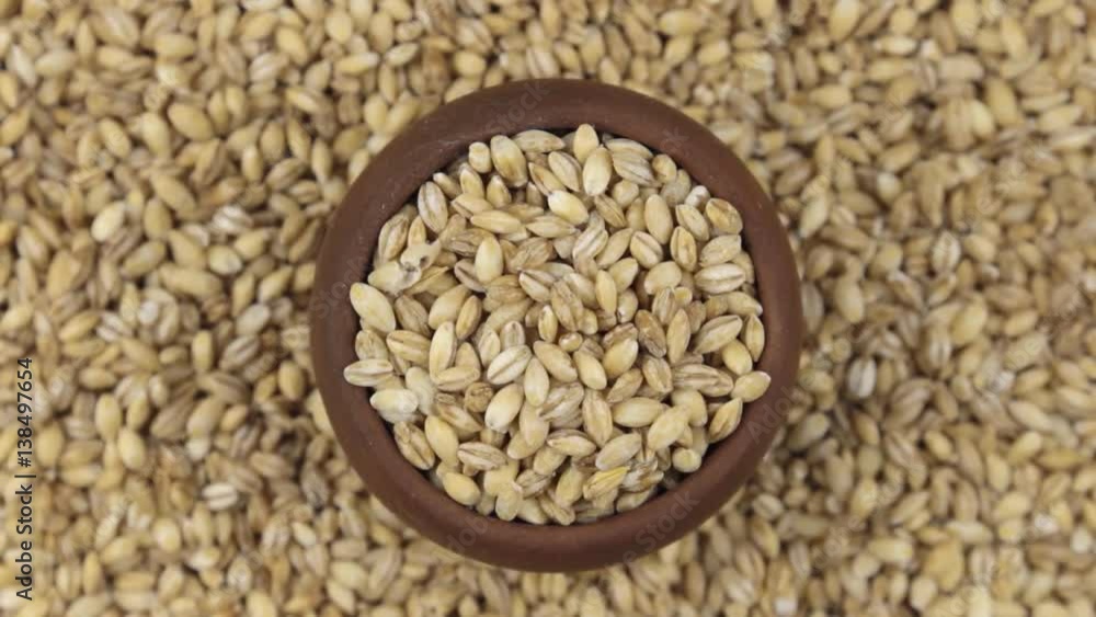 Slow rotation of the grain of pearl barley in a pot made of red clay. Slow rotation of the grain of pearl barley in a pot made of red clay.