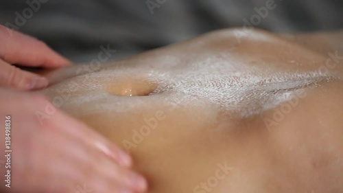 female hands do belly massage for a young girl