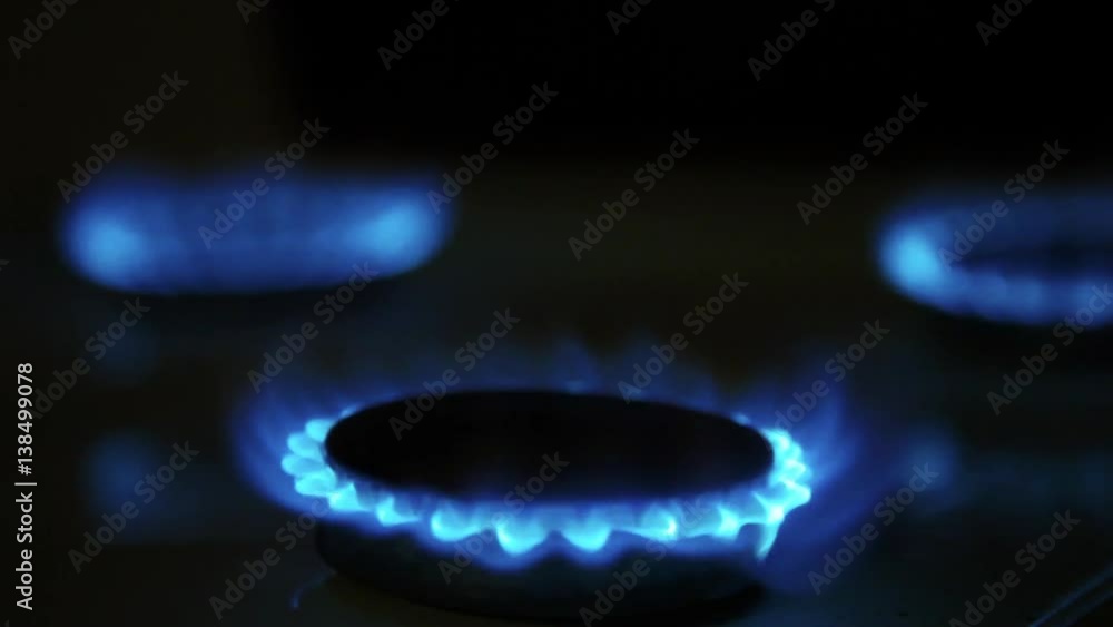 Cooktop with burning gas ring. Gas cooker with blue and yellow flames in dark. Cooktop with burning gas ring. Gas cooker with blue and yellow flames in dark.