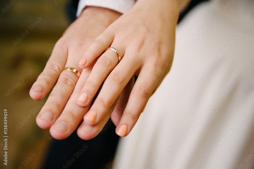 Newlyweds staying arm in arm, with wedding rings Newlyweds staying arm in arm, with wedding rings