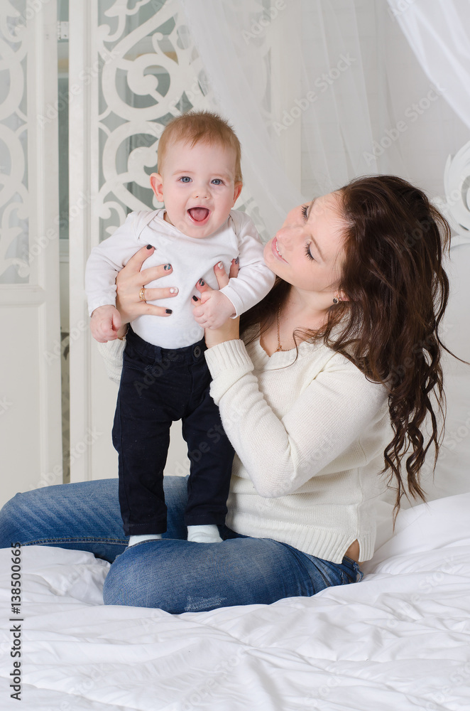 Happy mother playing and hug with little boy in bed Happy mother playing and hug with little boy in bed