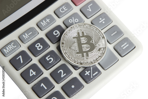 silver bitcoin lies on the calculator