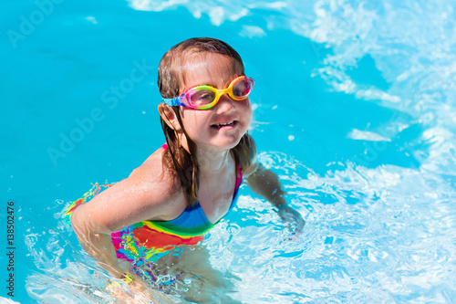 Child learning to swim in pool