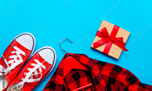 big red gumshoes, shirt on hanger and beautiful gift on the wonderful blue background photo