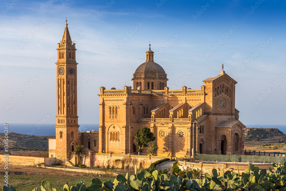 Gozo, Malta - The Basilica of the National Shrine of the Blessed Virgin of Ta' Pinu at sunset with clear blue sky on a summer day