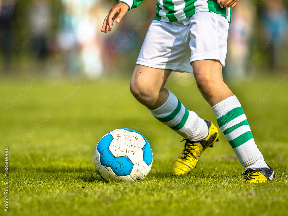 Boy playing soccer sport on natural grass pitch Boy playing soccer sport on natural grass pitch