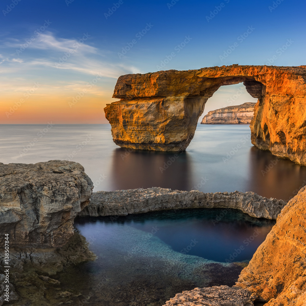 Fototapeta Gozo, Malta - Zachód słońca w pięknym Lazurowym oknie, naturalny łuk i słynny punkt orientacyjny na wyspie Gozo