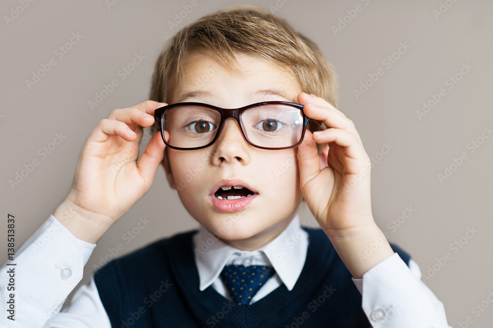 Portrait of schoolboy with glasses on grey background Portrait of schoolboy with glasses on grey background
