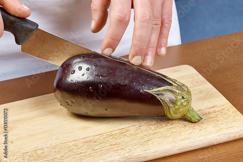 Cook hands cutting aubergine big