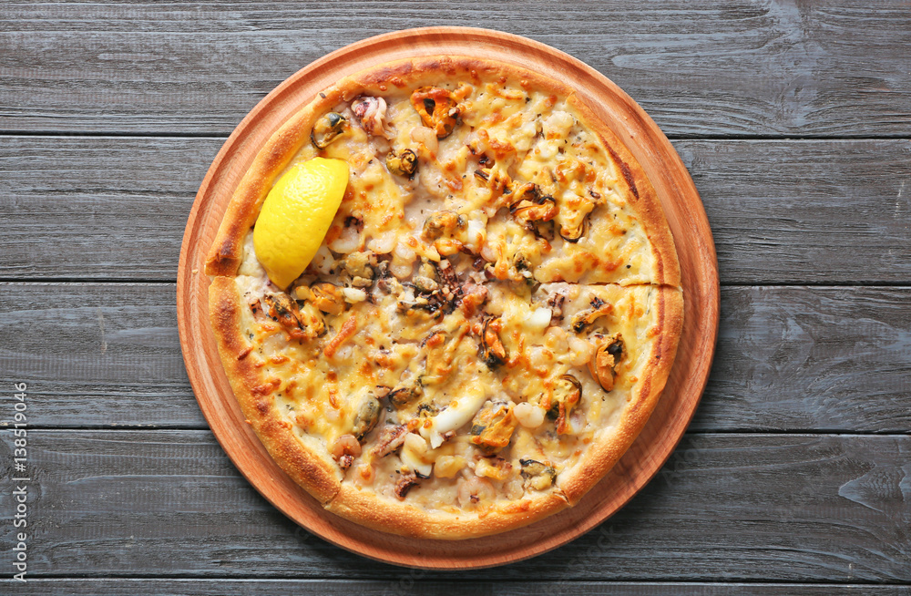 Delicious seafood pizza on grey wooden background Delicious seafood pizza on grey wooden background