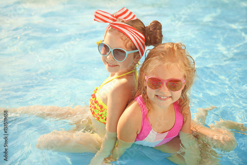 Little girls in swimming pool on sunny day © Africa Studio