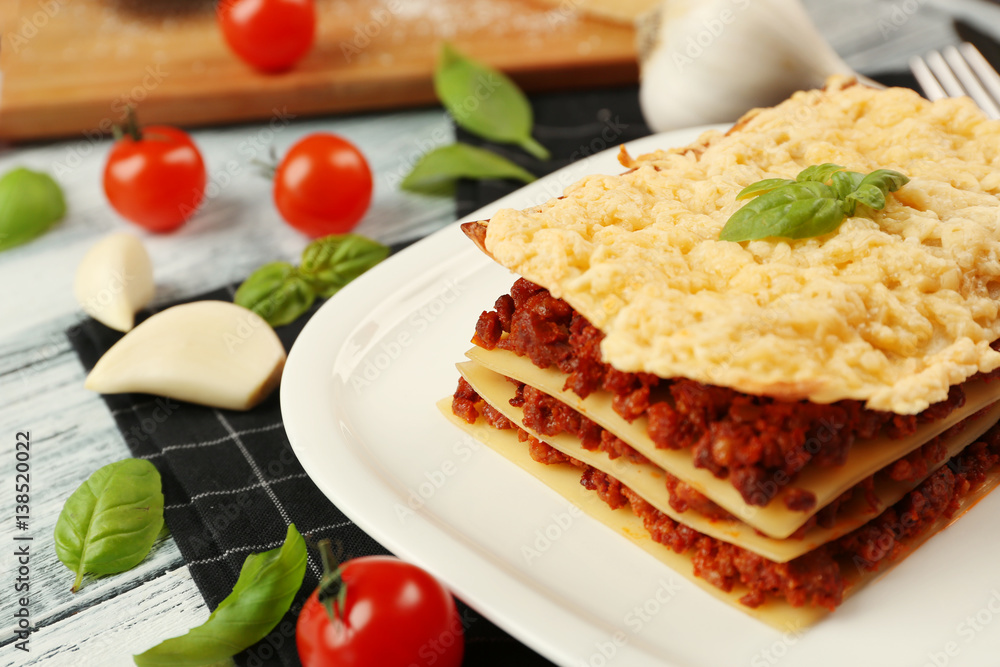 Plate with tasty lasagna on white wooden background Plate with tasty lasagna on white wooden background