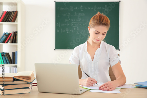 Young teacher at desk in cl...