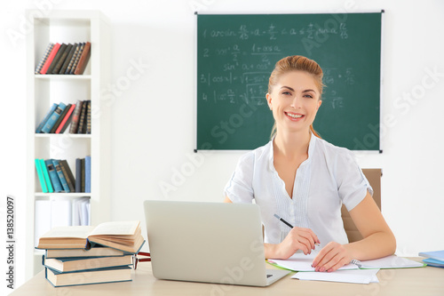 Young teacher at desk in cl...