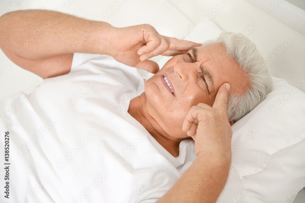 Senior gentleman suffering from pain in bedroom Senior gentleman suffering from pain in bedroom