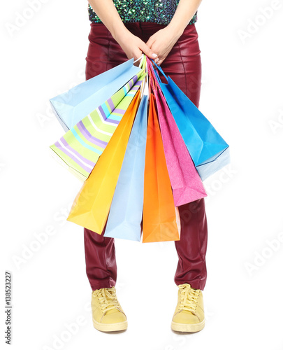 Woman's legs and shopping bags on light background