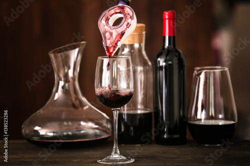 Pouring wine in glass on wooden table