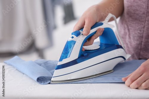 Woman ironing clothes at home