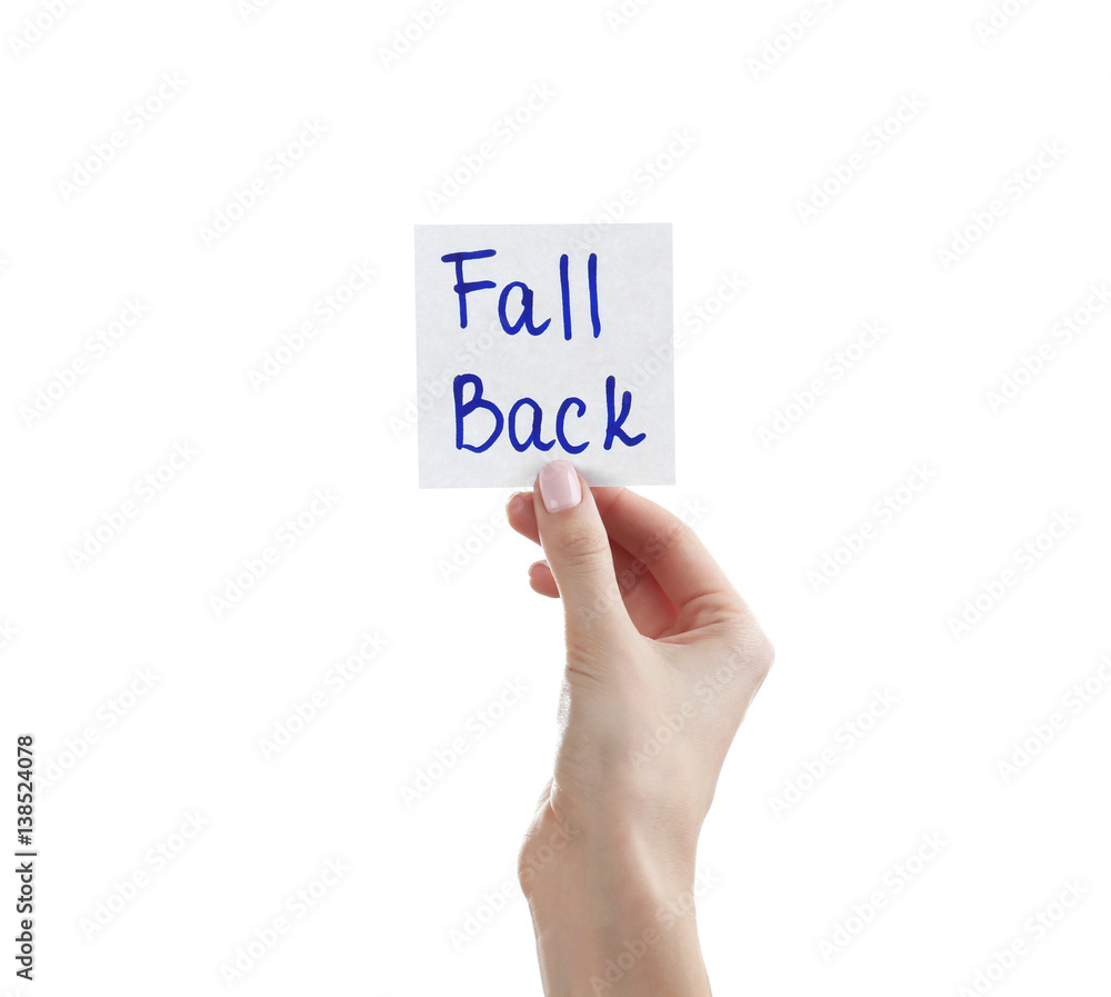 Female hand holding note with phrase FALL BACK on white background Female hand holding note with phrase FALL BACK on white background