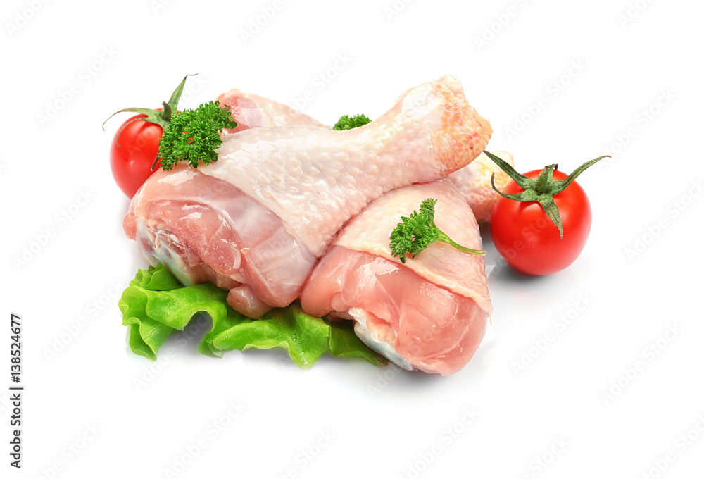 Raw chicken legs with lettuce and tomatoes on white background Raw chicken legs with lettuce and tomatoes on white background