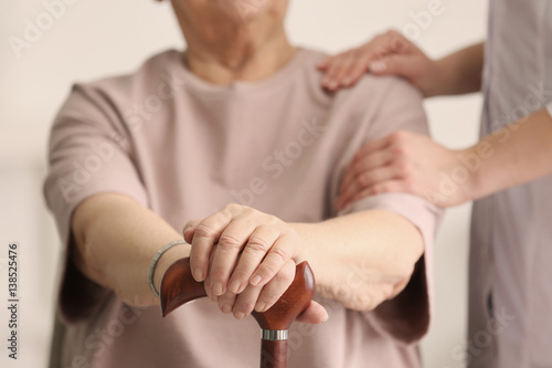 Female hands on walking stick closeup